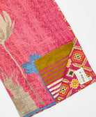kantha quilt throw with a tag featuring the hand-stitched signature of the maker