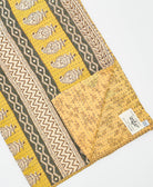 kantha quilt throw with a tag featuring the hand-stitched signature of the maker