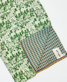kantha quilt throw with a tag featuring the hand-stitched signature of the maker