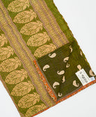 kantha quilt throw with a tag featuring the hand-stitched signature of the maker