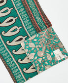 kantha quilt throw with a tag featuring the hand-stitched signature of the maker