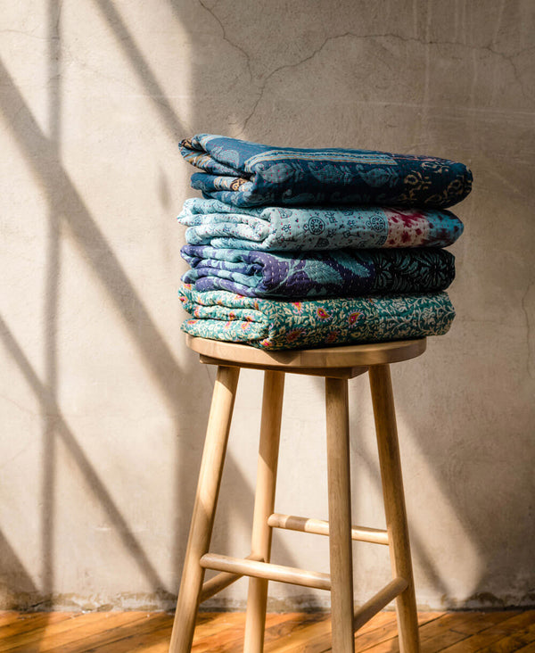 stack of blue patterned vintage kantha quilt throws by Anchal Project