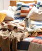 orange and blue kantha quilt throw draped over modern bedding 