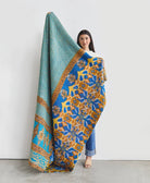 5'7" woman holding large kantha blanket in blue & mustard floral print handmade in India