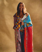 woman wrapped in colorful kantha quilt handmade in India by all women artisans