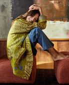 woman wearing cardigan-style kantha quilted jacket handmade in India from lime green and white vintage saris