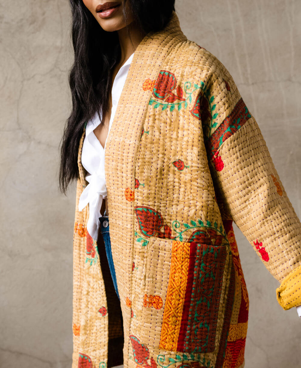 woman wearing golden yellow open front quilted jacket with front pockets handmade in India by artisans