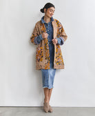 yellow and navy open front quilted jacket with hand-embroidery on woman wearing a denim dress