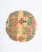 light tan round pillow with green and red geometric square pattern handmade by Anchal artisans