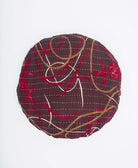 dark brown round pilow in red, white and tan swirls