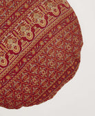 brick red circle pillow with tan and orange paisley diamond pattern with blue kantha stitching