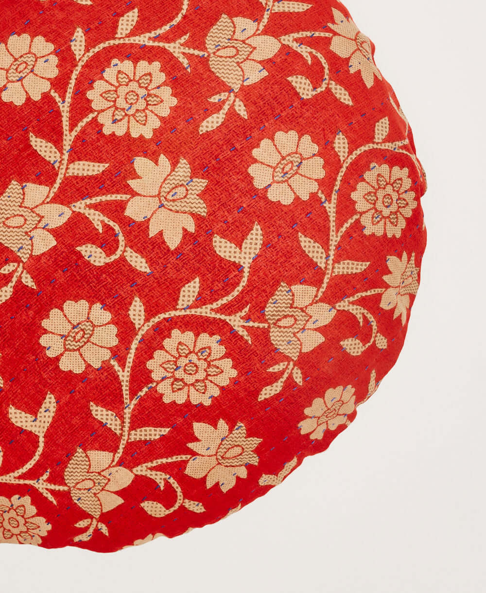 artisan-made round pillow in bright red with beige flower print