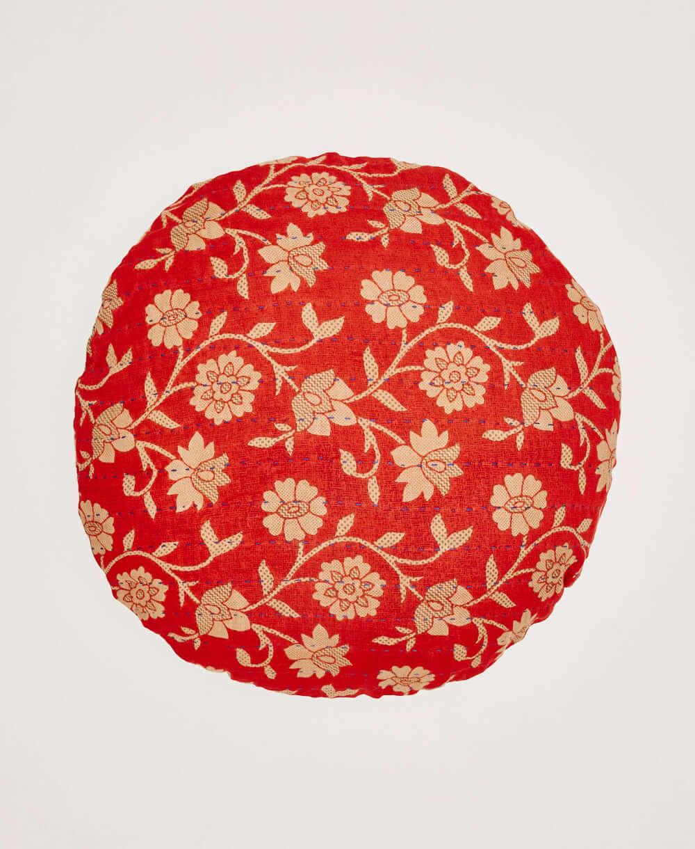 bright red round pillow with tan oversized floral pattern & blue kantha stitching