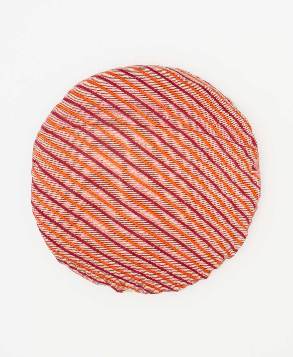 round pillow featuring a brufundy and orsnge stripe pattern 