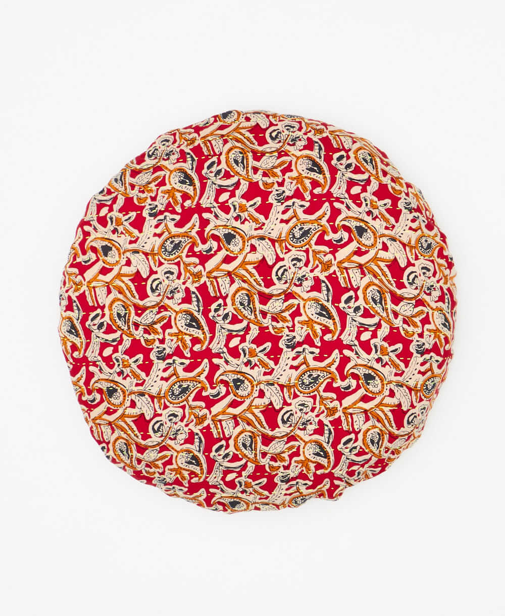 artisan made round pillow featuring a red and orange pattern 