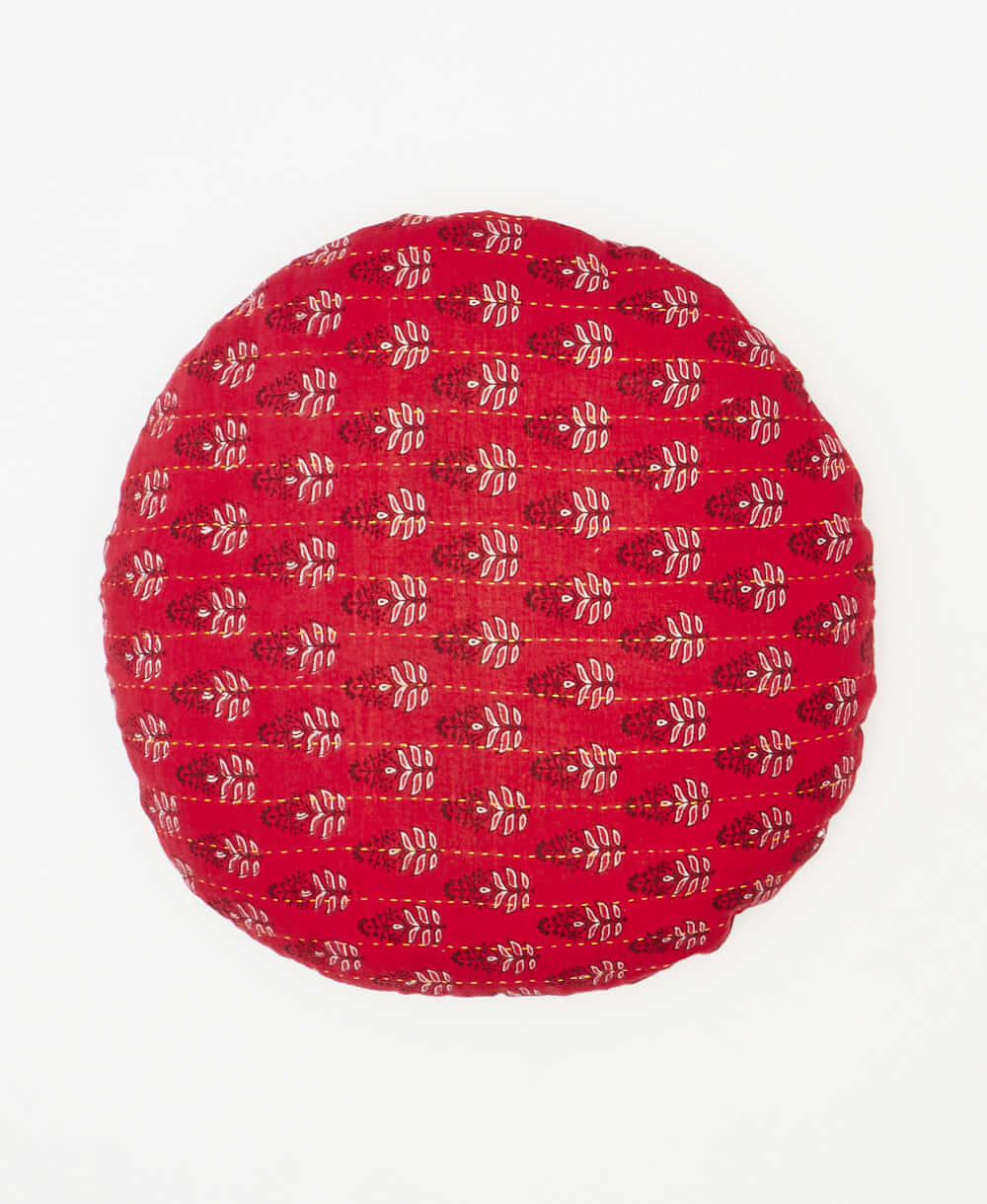 round pillow featuring a red white and black stamp floral print 