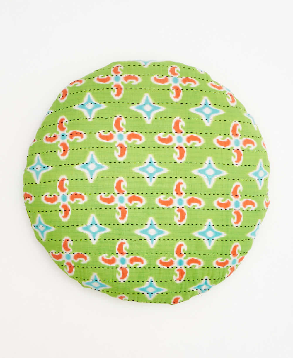 lime green and orange round pillow with a geometric pattern