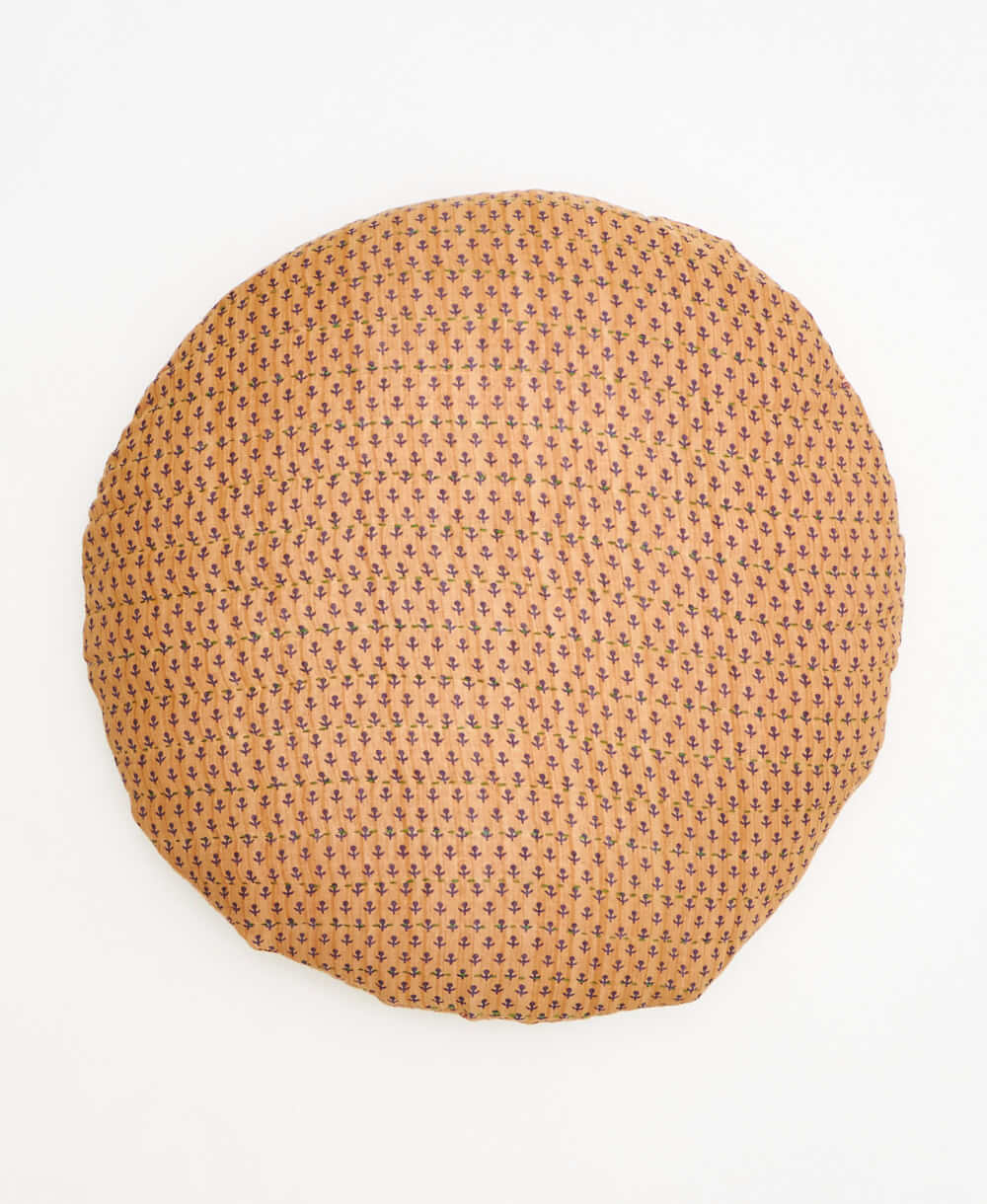 tan round pillow with delicate navy floral details