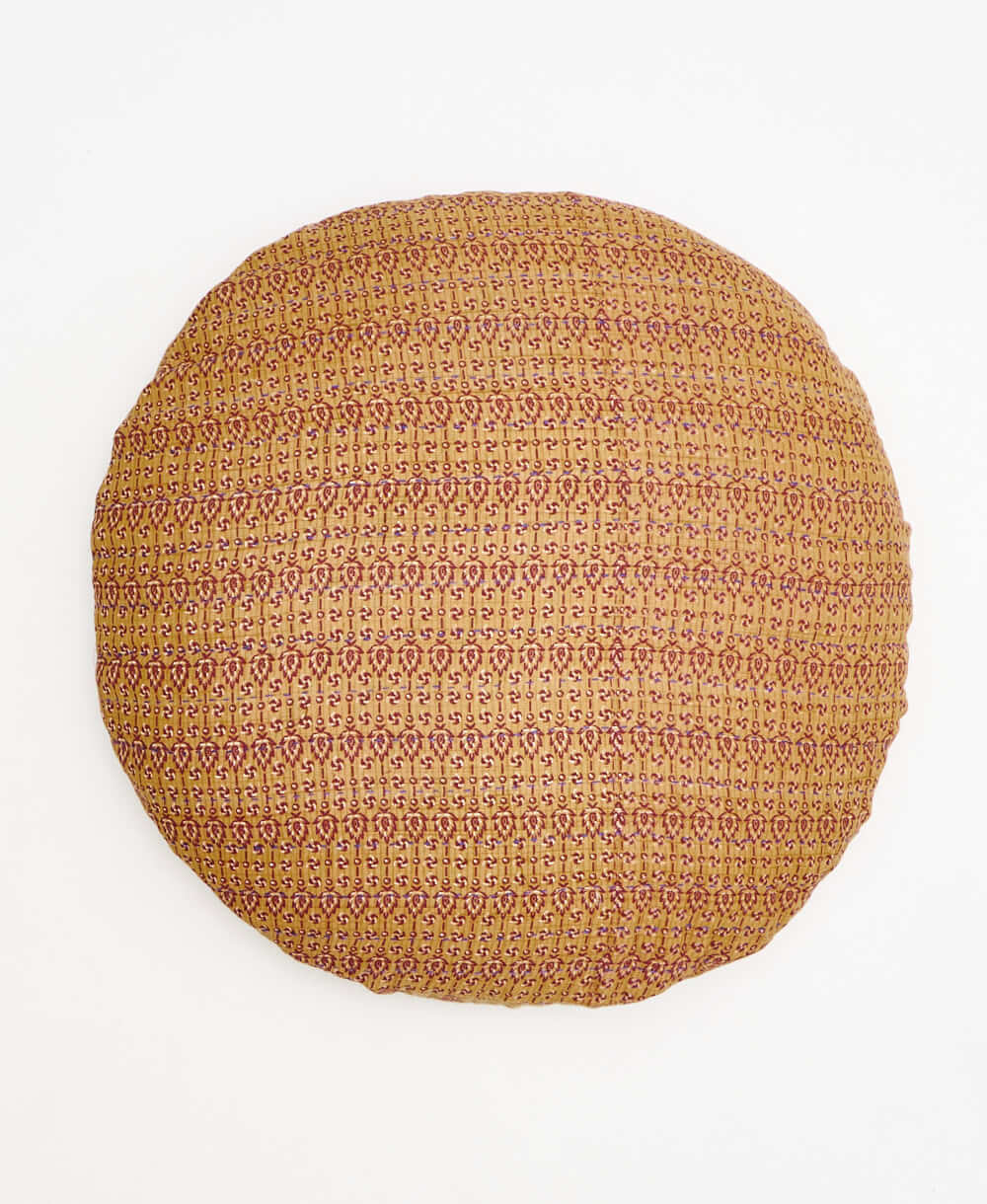 tan and red paisley round pillow with handstitched details 