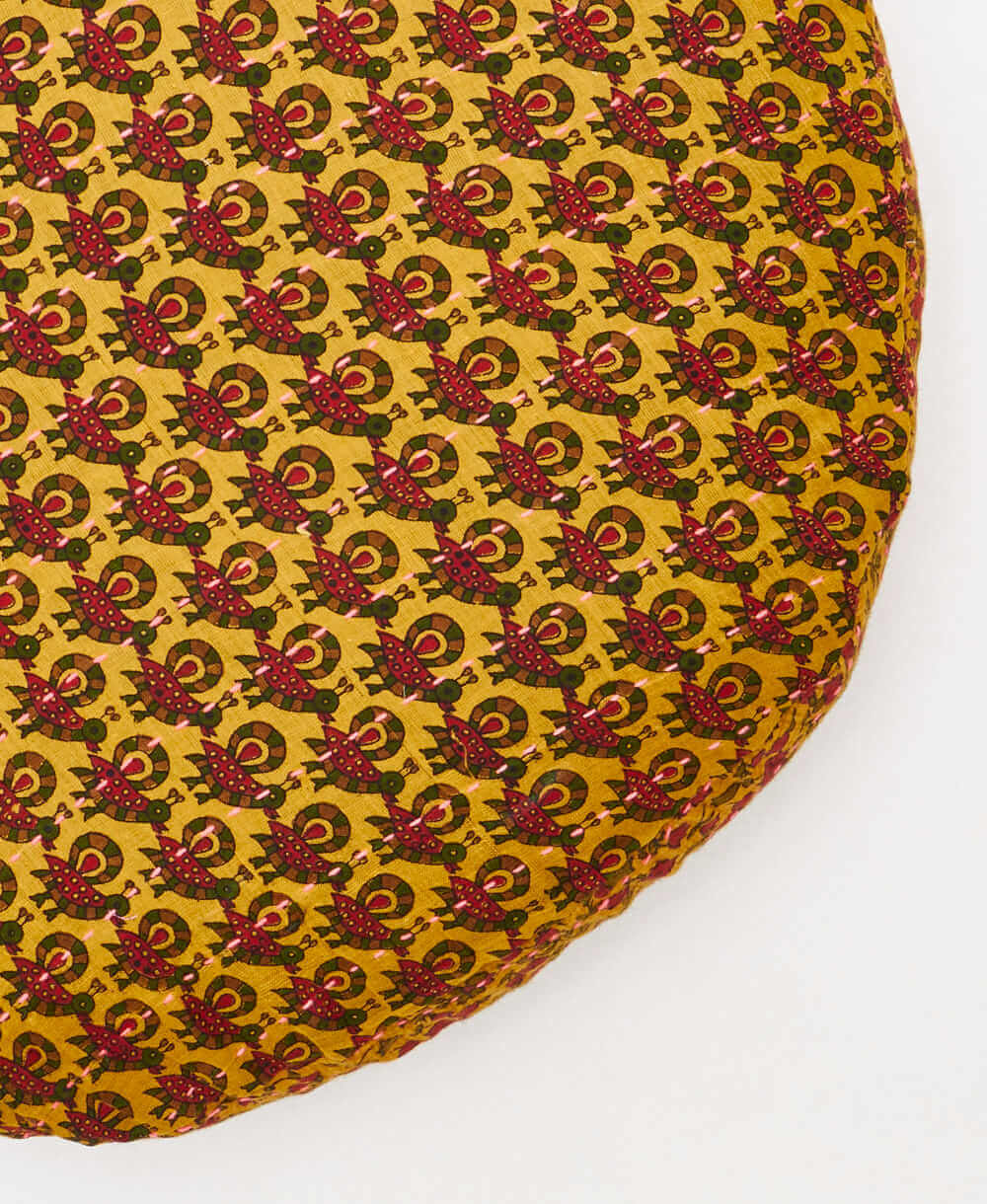 yellow, red, and green, circle pillow with handstitched details 