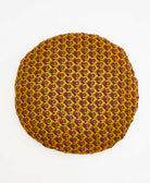 mustard yellow round pillow with a green and red peacock pattern