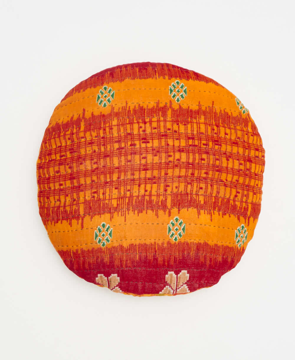 red and orange striped round pillow with handstitched details 