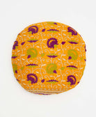 orange round pillow with green and purple swirling floral details 