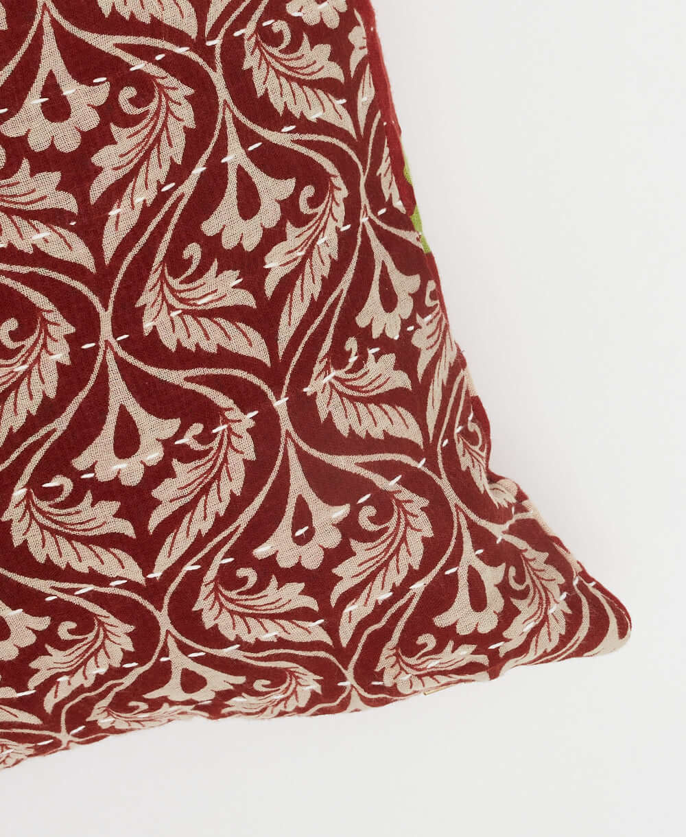 white kantha embroidery on dark red small throw pillow with tan leaf scroll print