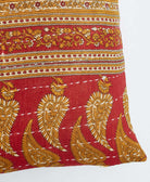 white kantha embroidery on red small throw pillow with mustard paisley print