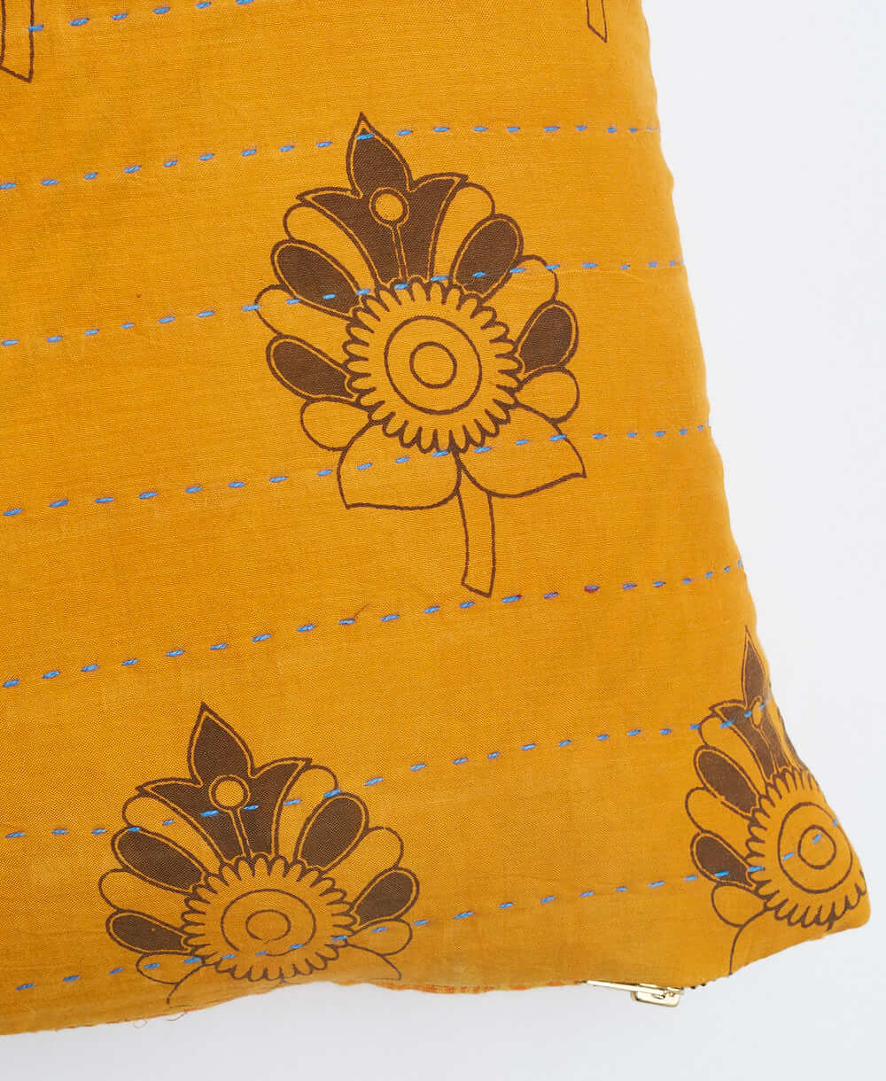 blue kantha embroidery on orange small throw pillow with bold brown floral print