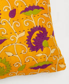 purple kantha embroidery on orange small throw pillow with a bold eggplant and lime green floral print