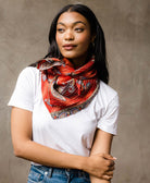 woman with oversized rust red paisley square scarf tied uniquely around her neck