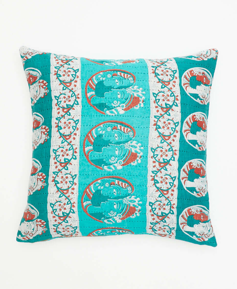 turquoise throw pillow with Indian patterns in orange & white accents