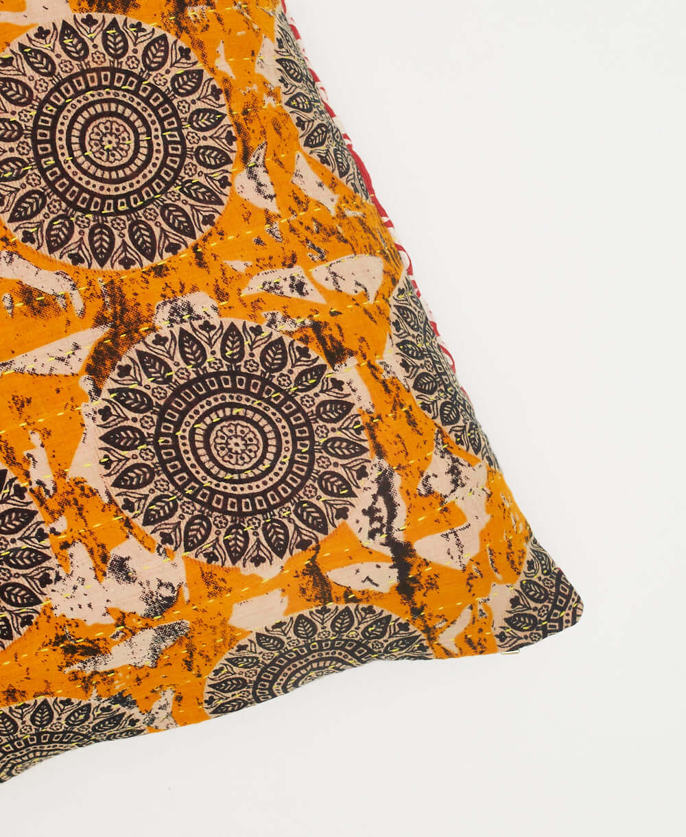 ethically made square pillow with orange and black and white medallion pattern