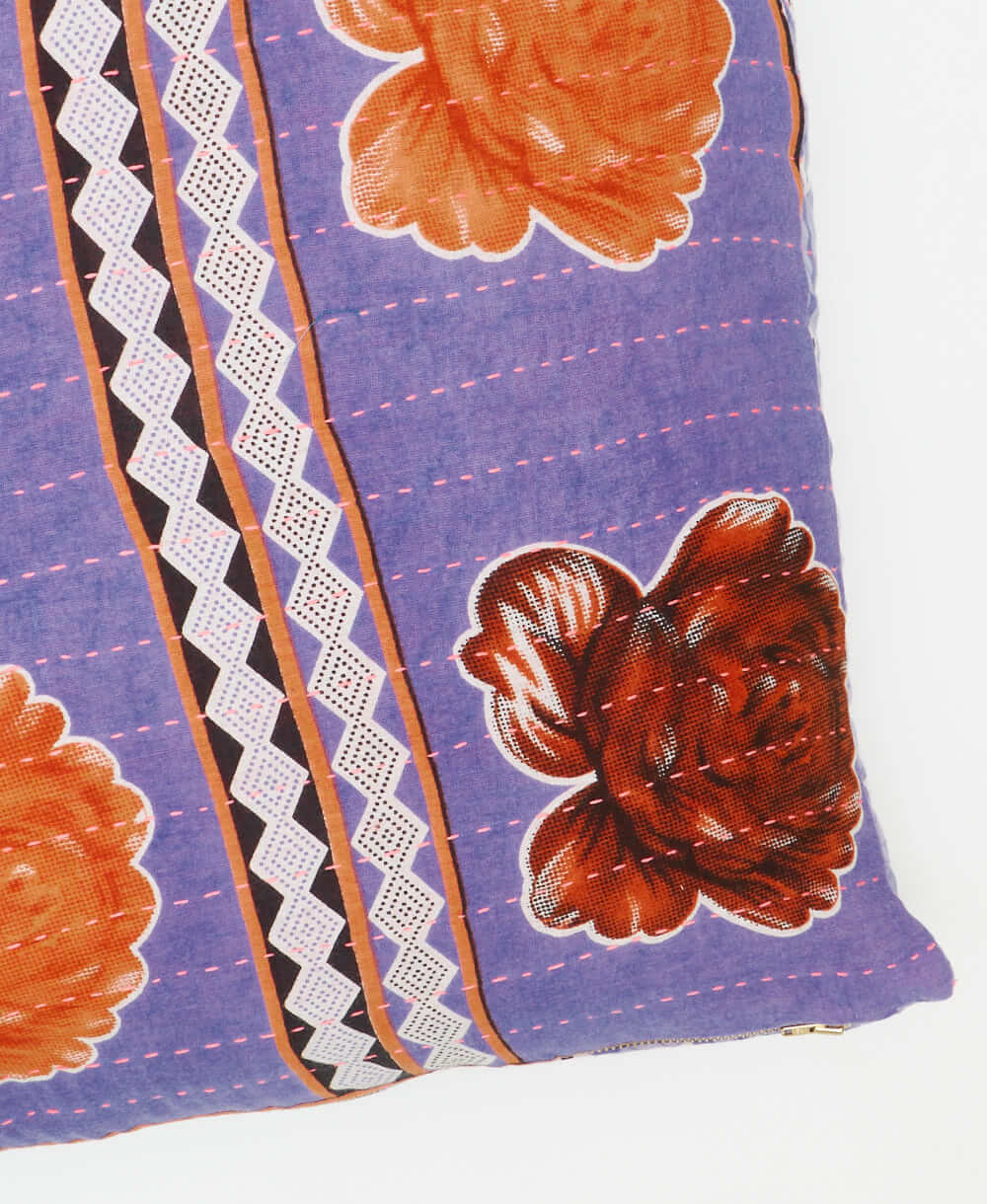 square pillow featuring a lavender and peach floral design and traditional hand stitching 