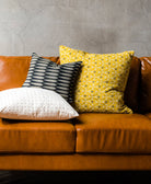 unique throw pillows in different sizes on modern brown leather sofa by Anchal