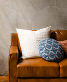 round blue pillow on brown leather sofa handmade in India by all women artisans from vintage saris