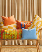 colorful organic cotton and vintage throw pillows on light wooden modern bench
