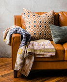 sustainable throw pillow on brown leather sofa in brown diamond and navy diamond print made in India