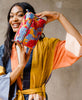 Woman holding vintage kantha toiletry bag wearing a color block robe