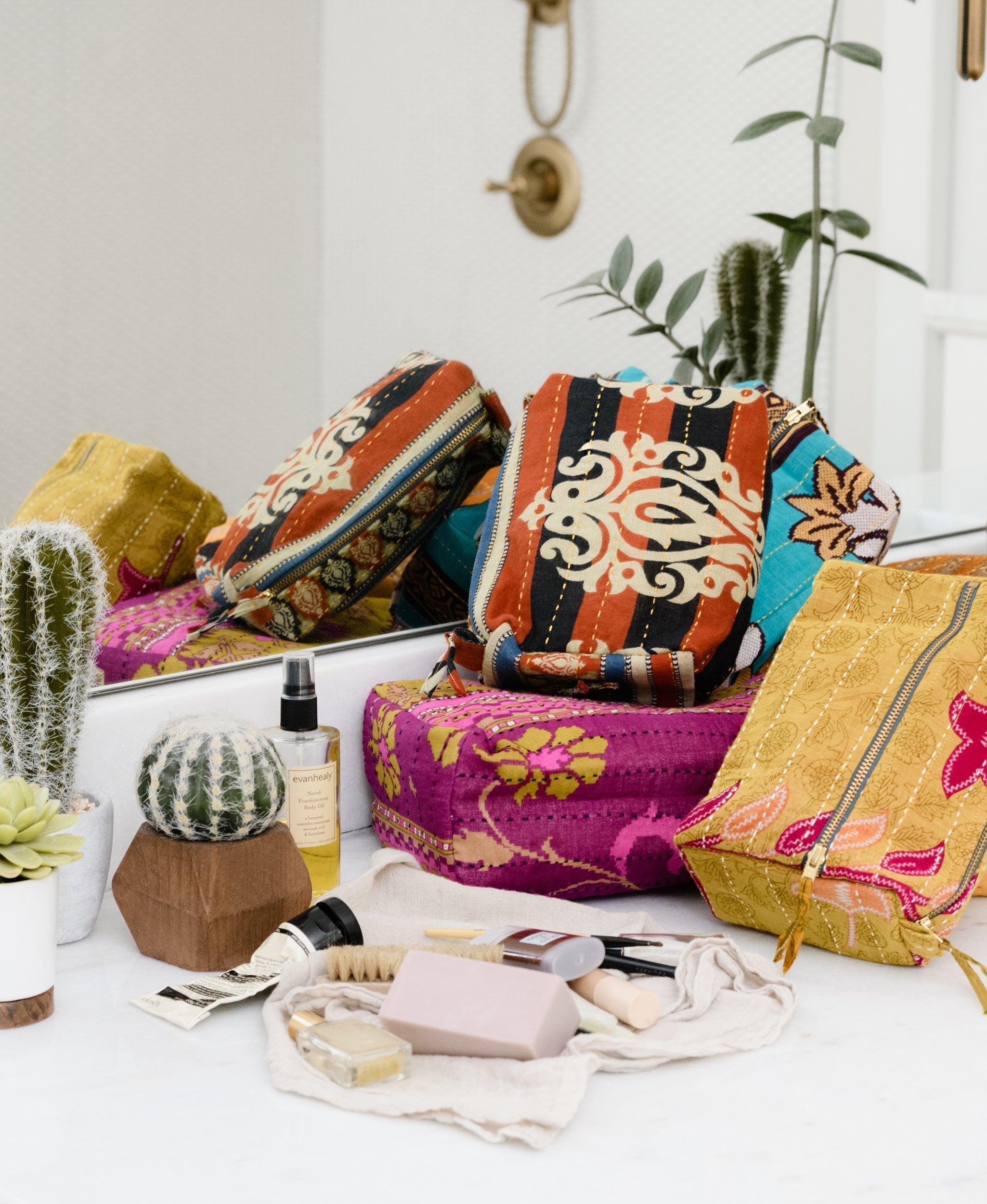 One-of-a-kind vintage kantha toiletry bags sitting on a
bathroom counter