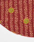 brick red reversible tree skirt made with a tan vine pattern and yellow kantha stitching