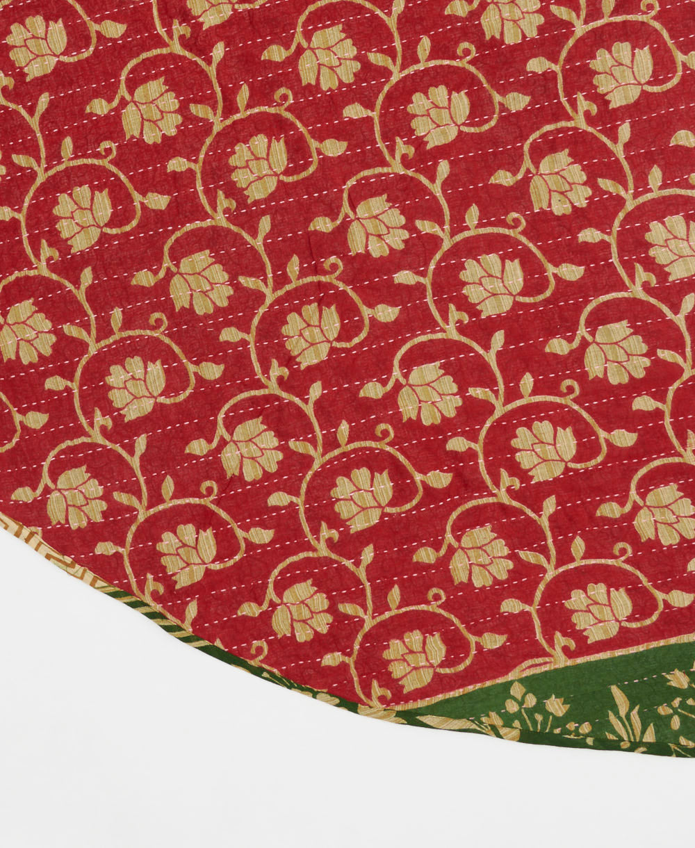 true red reversible tree skirt made with a tan floral vine pattern with neon pink kantha stitching