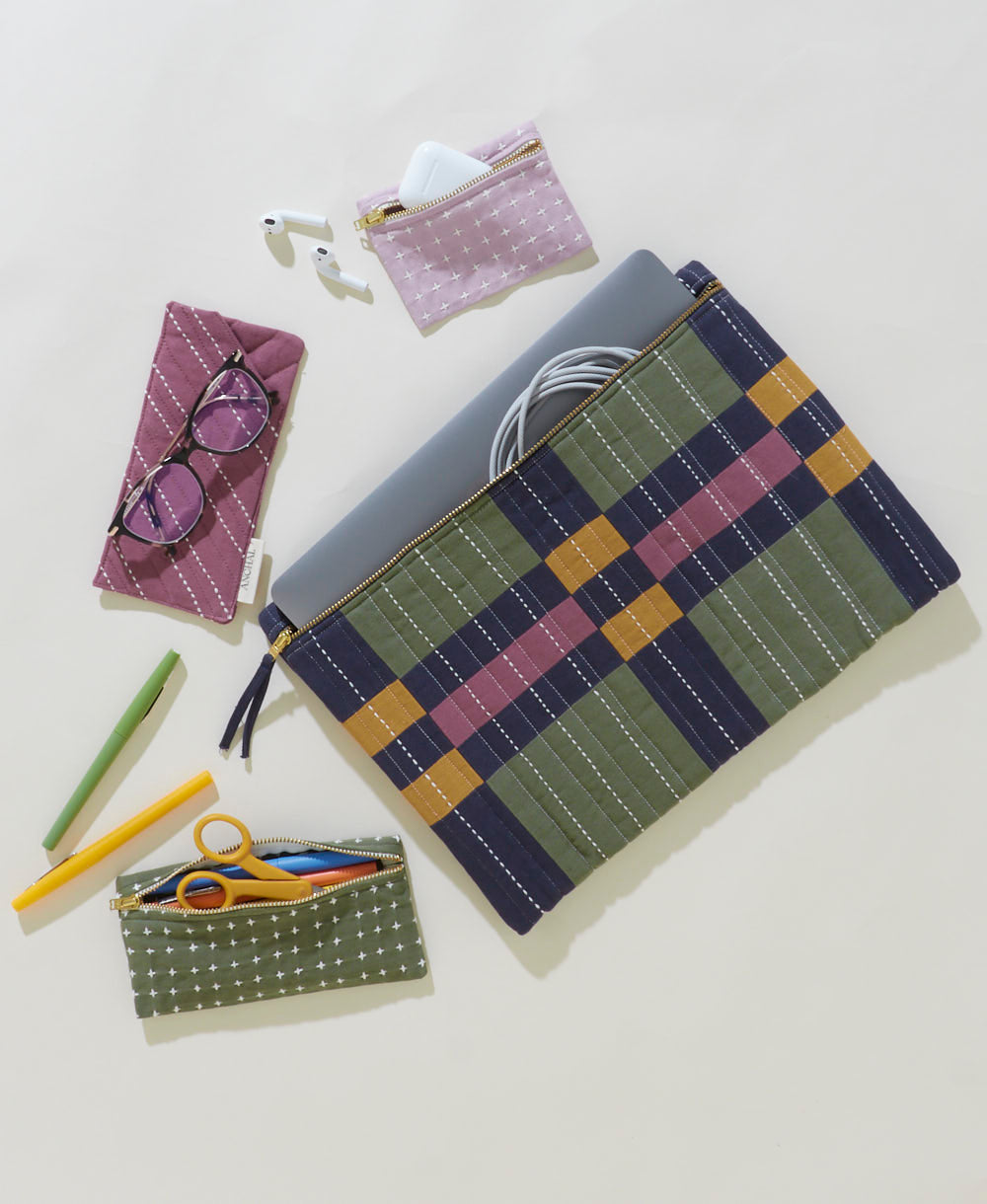 Plaid pouch with laptop and accessories on a light background