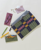 Plaid pouch with laptop and accessories on a light background