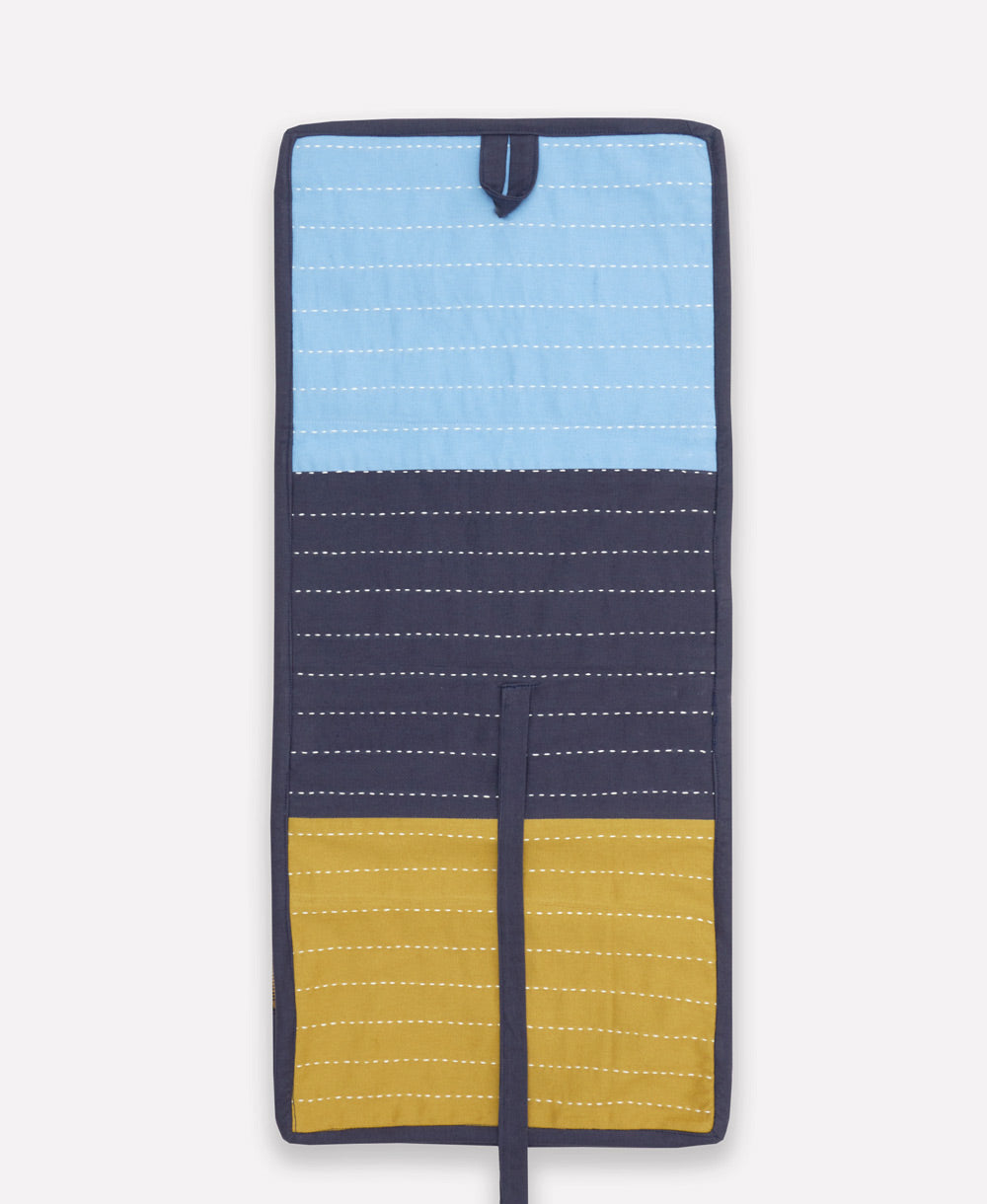 Multicolored fabric travel organizer with blue, yellow, and navy sections on a white background