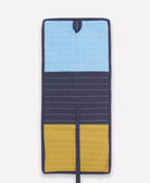 Multicolored fabric travel organizer with blue, yellow, and navy sections on a white background