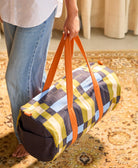 someone holding colorful canvas duffle bag while walking 