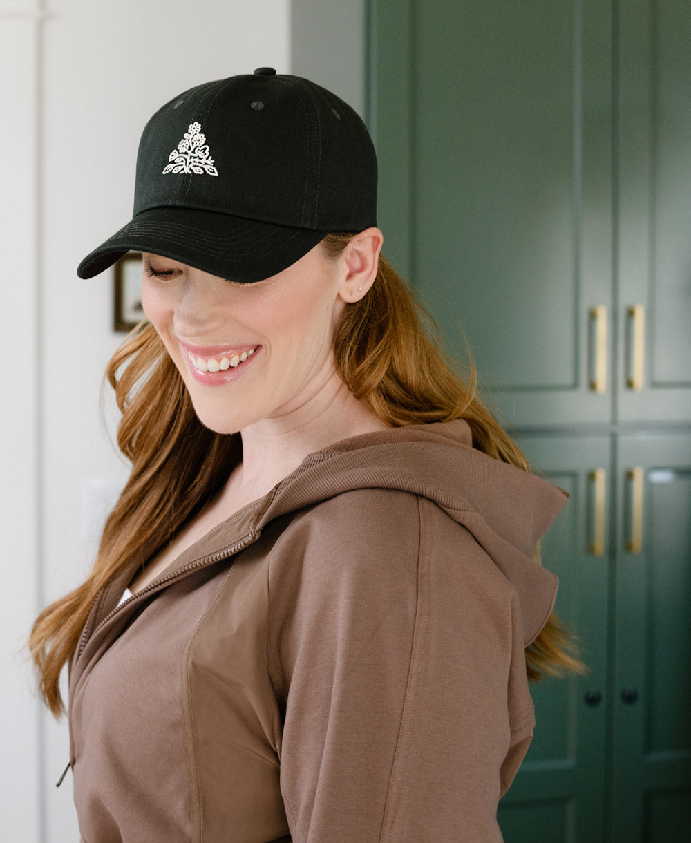 baseball hat in hunter green with thick embroidered logo on front and back of hat