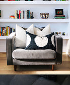 Gray armchair with decorative pillows in a room with bookshelves